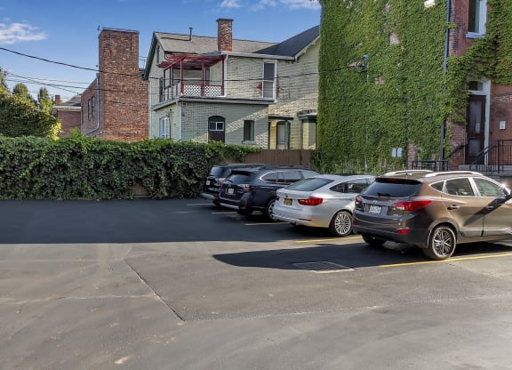 a parking lot filled with cars in front of a building at The Granite Works Apartments , New York 14202