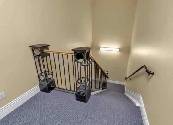 the upstairs landing of a home with a stairwell and a railing and a staircase at The Granite Works Apartments , Buffalo, NY, 14202