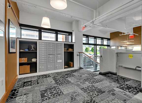 the lobby of a building with a reception desk and a door to a staircase at 100 South Apartments, Buffalo, NY