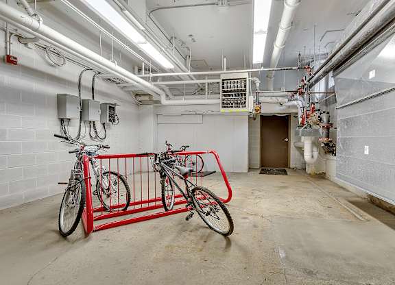 a bike rack with two bikes in the middle of a room at 100 South Apartments, Buffalo