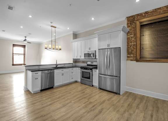 A modern kitchen with wooden floors and stainless steel appliances at The Knights @ 506 Delaware Apartments, Buffalo, New York