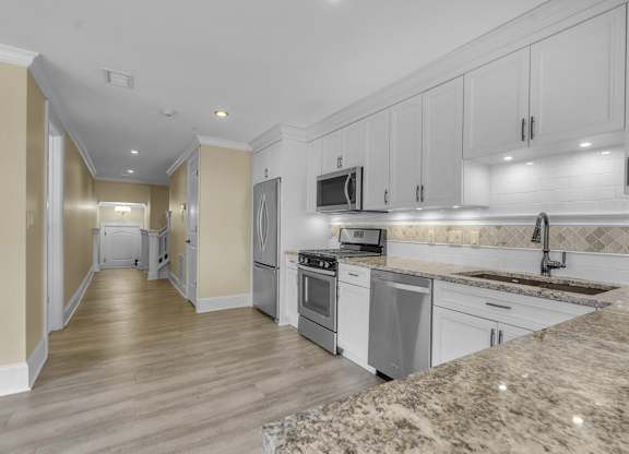 A kitchen with granite countertops and stainless steel appliances at The Knights @ 506 Delaware Apartments, Buffalo