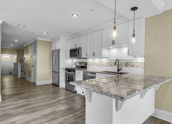 A kitchen with a granite countertop and stainless steel appliances. at The Knights @ 506 Delaware Apartments, Buffalo, NY