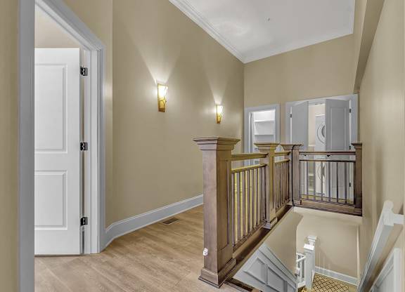 the landing of a staircase in a home with a door to a hallway at The Knights @ 506 Delaware Apartments, Buffalo, NY