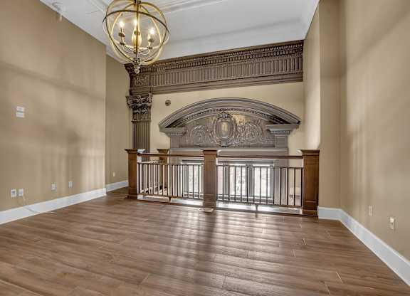 a large living room with a fireplace and a wooden floor at The Knights @ 506 Delaware Apartments, Buffalo, 14202