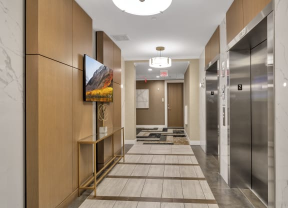 a long hallway with elevators and a painting on the wall at Nineteen North, Buffalo, NY, 14202