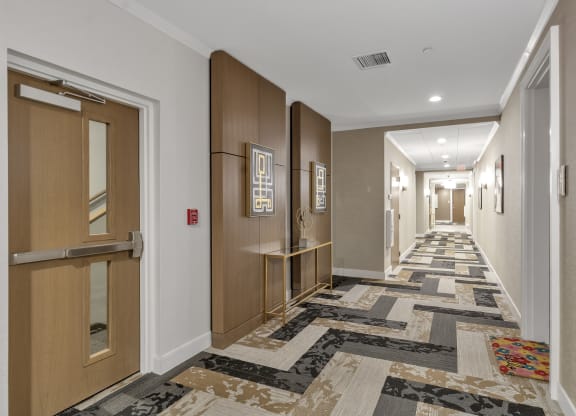 a long hallway with doors and carpeted floors at Nineteen North, Buffalo, 14202