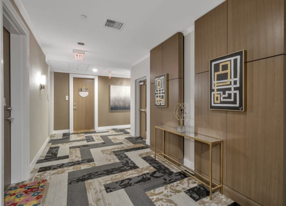 a hallway with carpeted floors and wooden walls and doors at Nineteen North, Buffalo, NY