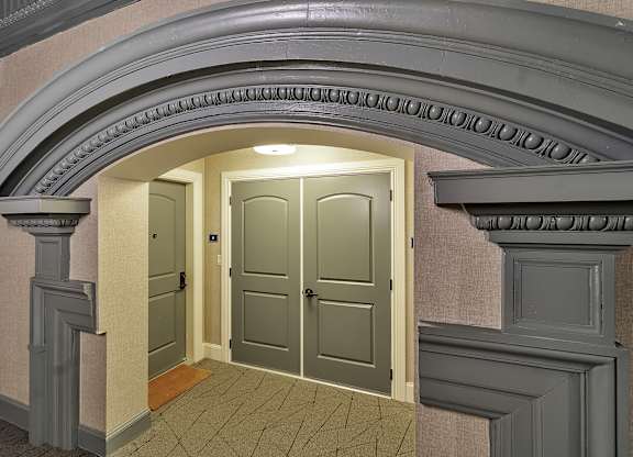 an empty hallway with an archway and two doors at The Knights @ 506 Delaware Apartments, Buffalo, NY 14202