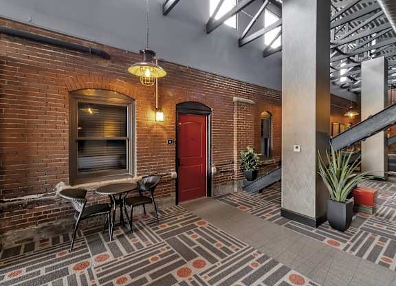the lobby of a building with a red door and a table and chairs at The Knights @ 506 Delaware Apartments, Buffalo, New York