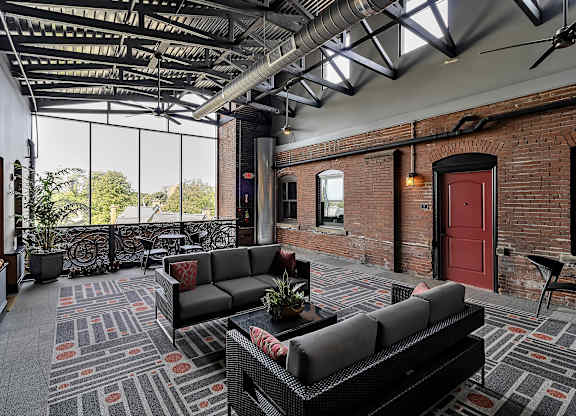 a living room with couches and a red door at The Knights @ 506 Delaware Apartments, Buffalo, NY