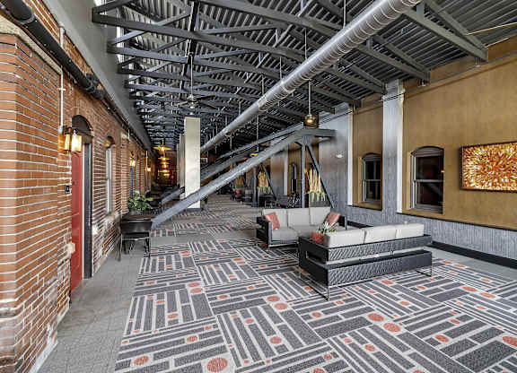 the lobby of a building with couches and a rug at The Knights @ 506 Delaware Apartments, Buffalo, NY 14202