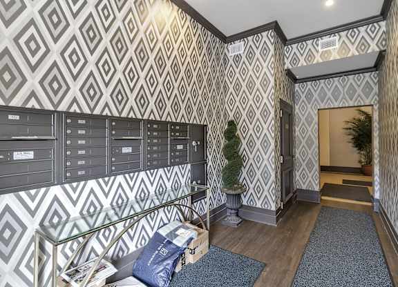 the lobby of a building with mailboxes and a tree in the corner at The Knights @ 506 Delaware Apartments, Buffalo