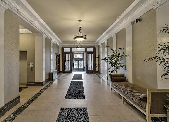 a hallway with a bench and plants and a chandelier at The Knights @ 506 Delaware Apartments, New York