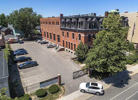 an aerial view of a brick building in a parking lot at The Knights @ 506 Delaware Apartments, New York