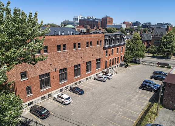 an aerial view of a brick building in a parking lot at The Knights @ 506 Delaware Apartments, Buffalo, New York