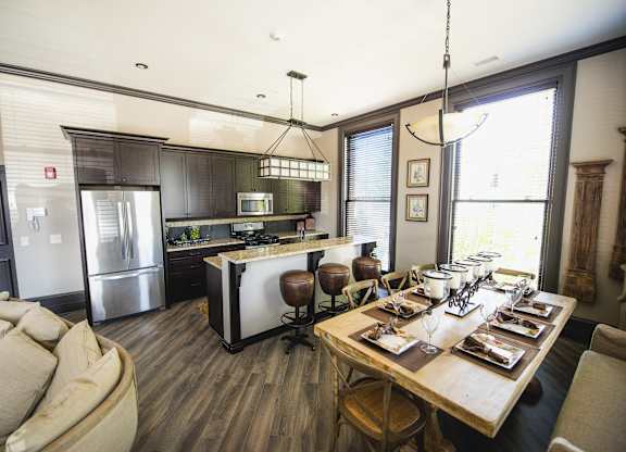 a kitchen and dining room with a table and chairs at The Knights @ 506 Delaware Apartments, Buffalo, NY 14202