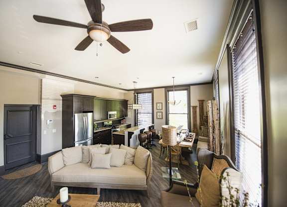 a living room and kitchen with a couch and a ceiling fan at The Knights @ 506 Delaware Apartments, New York