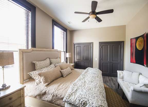 a bedroom with a large bed and a ceiling fan at The Knights @ 506 Delaware Apartments, Buffalo, 14202
