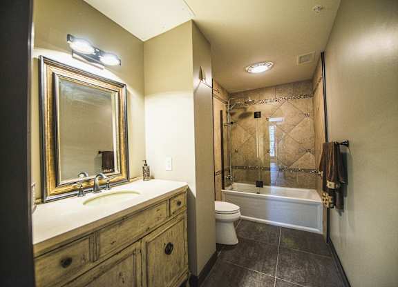 a bathroom with a sink and a shower and a toilet at The Knights @ 506 Delaware Apartments, Buffalo