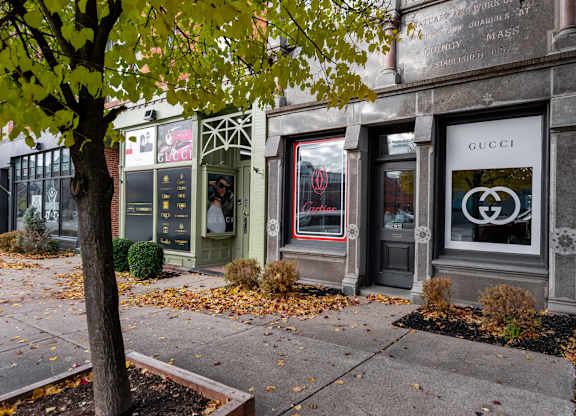 Luxury retail storefronts along tree lined sidewalk at The Granite Works Apartments, Buffalo, New York