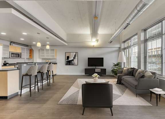 Open concept living room with modern furnishings at The Lofts at Elk Terminal Apartments, Buffalo, NY 14204