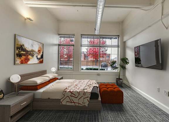 Modern bedroom with platform bed and wall mounted tv at The Lofts at Elk Terminal Apartments, New York