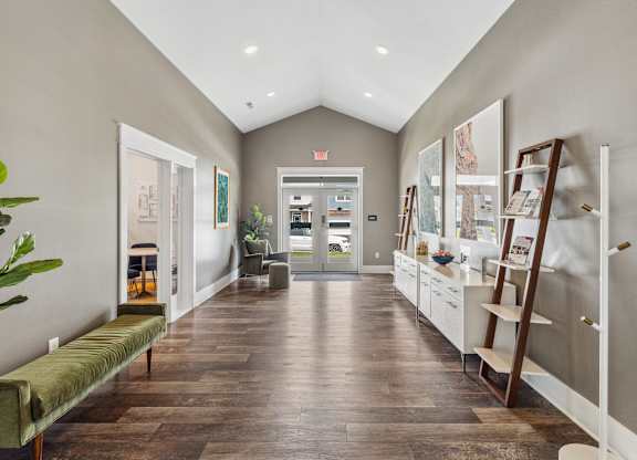 A long hallway with a bench and a plant on the left and a display of shelves on the right. at Highland Village, Ross Township, Pittsburgh, PA 15229