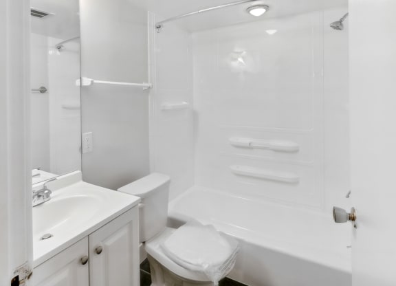 a white bathroom with a shower sink and toilet at Walnut Towers at Frick Park, Pittsburgh, Pennsylvania