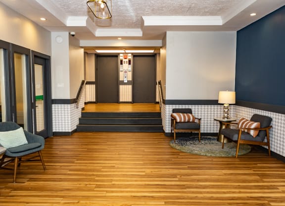 a seating area with chairs and tables in front of a door  at Walnut Crossings, Monroeville, PA, 15146