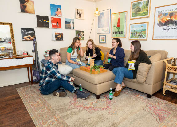 a group of people sitting on a couch in a living room at University Commons Apartments, Oakland, Pittsburgh