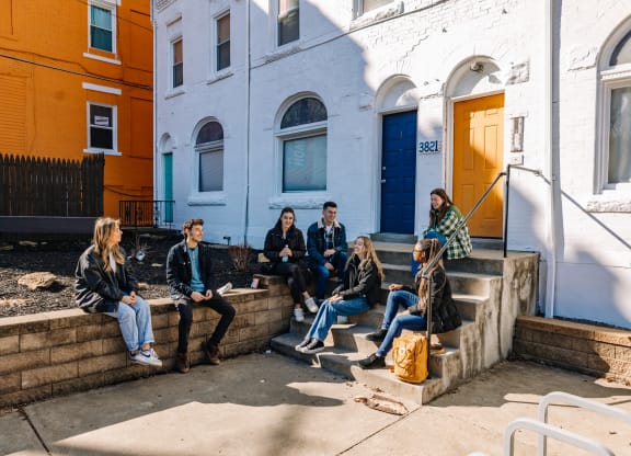 a group of people sitting on the steps of a building at University Commons Apartments, Oakland, Pittsburgh