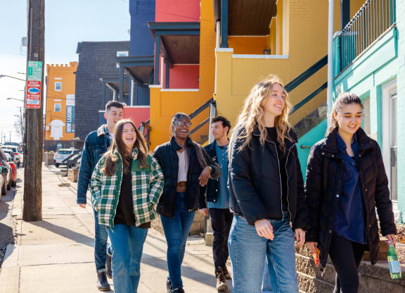 a group of young people walking down a street at University Commons Apartments, Oakland, Pittsburgh