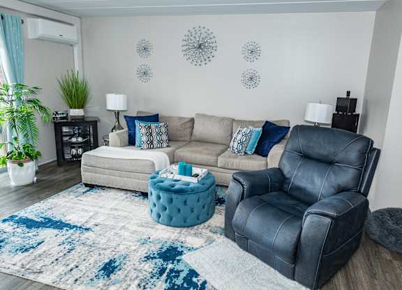 A living room with a black leather chair and a grey ottoman. at Walnut Crossings, Monroeville, PA, 15146