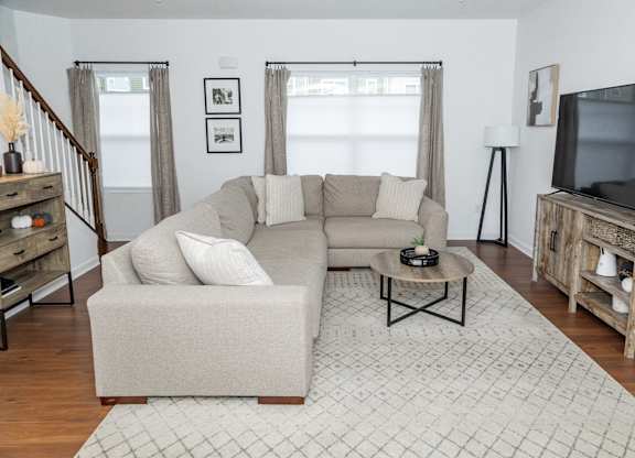 A living room with a couch, a coffee table, and a television. at Highland Village, Ross Township, Pittsburgh, PA 15229