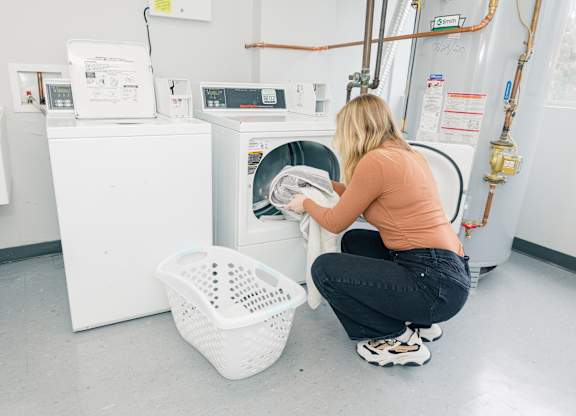 A woman is doing laundry in a laundromat at Walnut Towers at Frick Park, Pennsylvania 15217