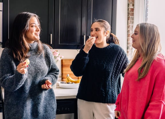 a group of women eating ice cream in a kitchen at University Commons Apartments, Oakland, Pittsburgh