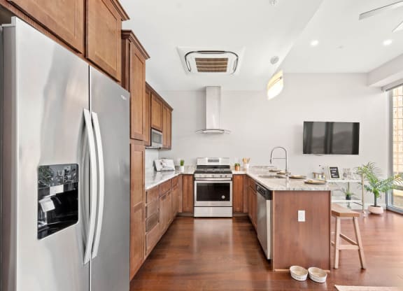 a kitchen with wood cabinetry and white walls at The Washington at Chatham, Pittsburgh