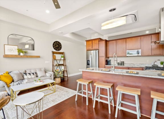 a kitchen with a long counter and a living room with a couch at The Washington at Chatham, Pittsburgh, PA 15219