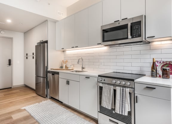 a kitchen with white cabinets and stainless steel appliances and a microwave at The Commonwealth Building, Pittsburgh, 15222