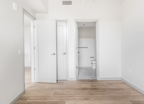 an empty room with white walls and doors to a bathroom at The Commonwealth Building, Pittsburgh, 15222