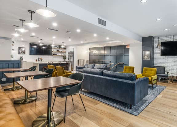 a living room with couches tables and chairs and a tv at The Commonwealth Building, Pittsburgh, 15222