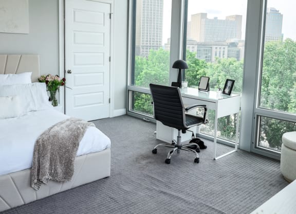 a bedroom with a bed and a desk in front of a window at The Washington at Chatham, Pittsburgh Pennsylvania