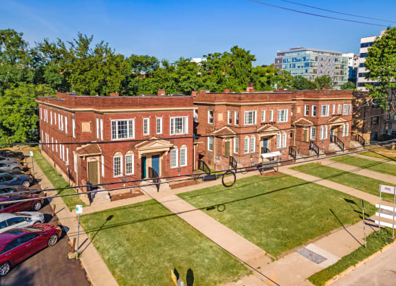 a large brick building with a grassy area in front of it at University Commons Apartments, Oakland, Pittsburgh