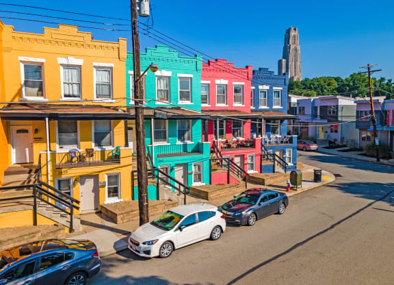 a row of colorful buildings on a city street at University Commons Apartments, Oakland, Pittsburgh