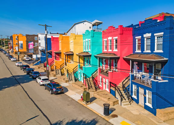 a row of colorful buildings on a city street at University Commons Apartments, Oakland, Pittsburgh