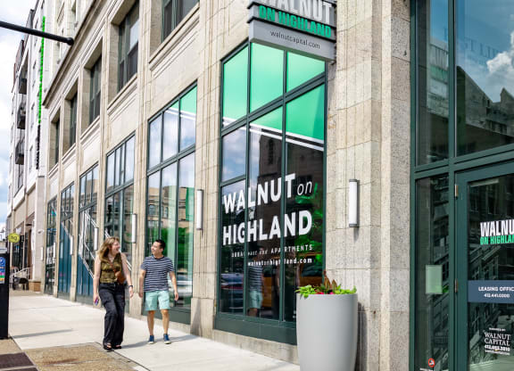 people walking down a sidewalk in front of a building at Walnut on Highland, Pittsburgh, PA