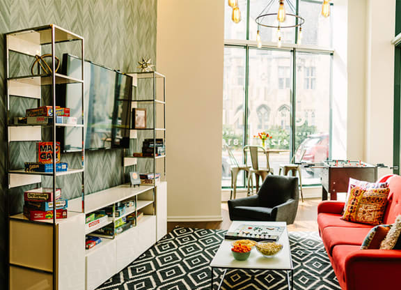 a living room with a red couch and black and white rug at Walnut on Highland, Pittsburgh, PA