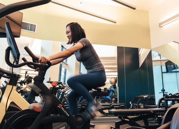 a woman riding an exercise bike in a gym at Walnut on Highland, Pittsburgh, PA