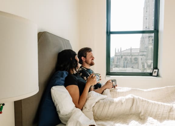 a couple sits in bed at Walnut on Highland, Pittsburgh, PA